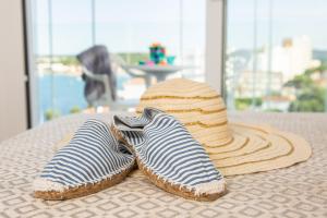 a pair of shoes and a straw hat on a table at RVHotels Nieves Mar in L'Escala