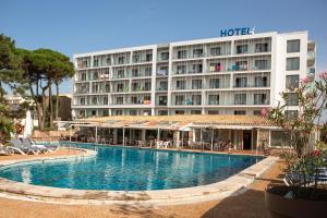 a hotel with a swimming pool in front of a building at RVHotels Nieves Mar in L'Escala