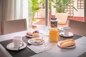 stół z butelką soku pomarańczowego i talerzami jedzenia w obiekcie Hotel Catalunya Express w mieście Tarragona