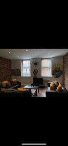 una gran sala de estar con sofás y una mesa. en Spacious Shude Hill Apartment With Balcony en Mánchester