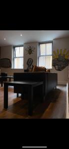 a living room with a couch and a table at Spacious Shude Hill Apartment With Balcony in Manchester