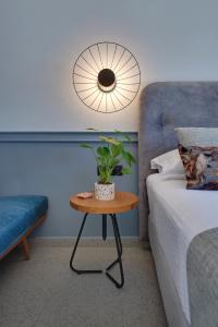 Un dormitorio con una mesa con una planta en una cama en Charisma Boutique Hotel, en Parga