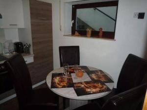 a dining room table with chairs and a mirror at Appartement-Landhaus-Kruse in Meschede