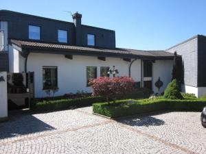 a white and black house with a brick driveway at Appartement-Landhaus-Kruse in Meschede