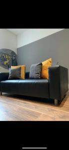 a black couch sitting in a living room at Spacious Shude Hill Apartment With Balcony in Manchester