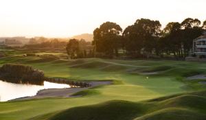 a view of a golf course with a pond at Empordà Golf Resort in Torroella de Montgrí