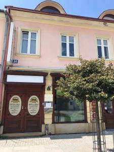 różowy budynek z dużymi drewnianymi drzwiami w obiekcie Hostel Promenada w mieście Rzeszów