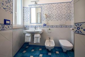 a bathroom with a toilet and a sink at Marina Grande Residence & SPA in Sorrento