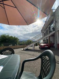 a table with an umbrella and a car on a street at Hostería Carmen in Santillana del Mar
