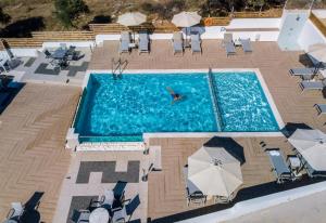 an overhead view of a pool with chairs and a person swimming in it at Studios Apartments Irini Patira in Potos