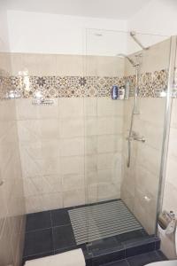 a shower with a glass door in a bathroom at Casuta Bradulet - Aeroport Otopeni & Therme in Baloteşti +22 photos