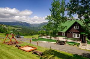 派克波特斯耐兹库Bouda Racek的一座带绿色屋顶的谷仓和一座建筑