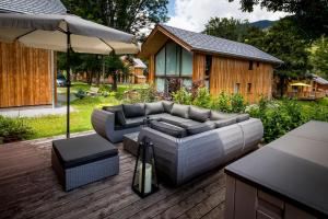 a patio with a couch and an umbrella at Luxury Chalet Kreischberg 11a in Sankt Lorenzen ob Murau