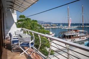 un balcón con 2 sillas y un barco en un puerto deportivo en Dolichi View, en Pythagoreio