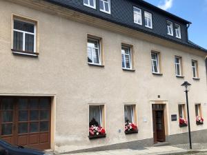 un bâtiment avec des fenêtres et des fleurs dans des boîtes de fenêtres dans l'établissement Ferienwohnung Buschbeck, à Marienberg