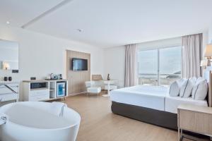a hotel room with a bed and a bath tub at Melia Sitges in Sitges