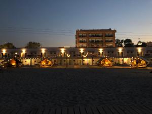 a large building with lights in front of it at Hostel Cazino Nord Rooms in Mamaia