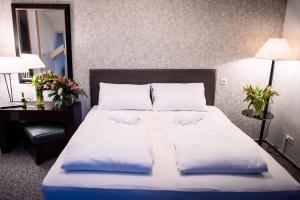 a bedroom with a bed with two pillows on it at Bölsche Hotel in Berlin