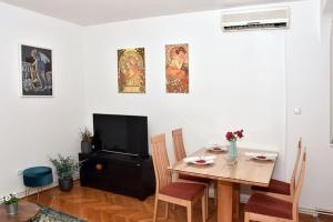 une salle à manger avec une table et une télévision dans l'établissement Apartman Vlaška 78, à Zagreb