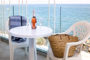 a white table with a bottle of wine and two chairs at RVHotels Nieves Mar in L'Escala