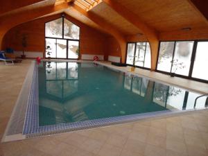 an indoor swimming pool in a building with windows at Hotel Miruna in Sâmbăta de Sus