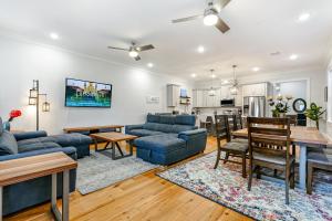 a living room with blue couches and a dining room at Stunning Modern and Fully-Upgraded 5 BR w Pool in New Orleans