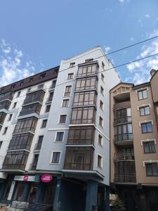 um edifício branco alto com janelas numa rua em НОВІ квартири біля вокзалу ІФ "ХОЧУ ЦЮ" em Ivano-Frankivsʼk