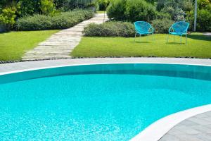 - deux chaises bleues installées à côté de la piscine dans l'établissement Maison Di Fiore B&B, à Ercolano