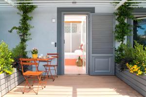 Une porte ouverte s'ouvre sur une terrasse avec une table et des chaises. dans l'établissement Maison Di Fiore B&B, à Ercolano