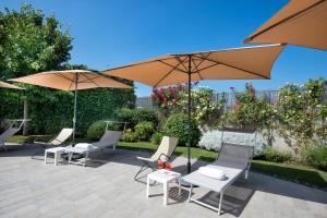 - un ensemble de chaises et de parasols sur une terrasse dans l'établissement Maison Di Fiore B&B, à Ercolano