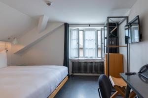 a bedroom with a bed and a desk at Marktgasse Hotel in Zurich