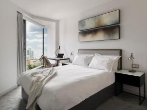 曼彻斯特CitySuites Aparthotel的卧室里有一张白色的大床和一扇窗户