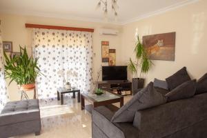 sala de estar con sofá y TV en Villa Paradise, en Pafos