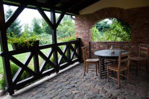 a patio with a table and chairs and a fence at Siedlisko Sabinowo in Węgorzewo