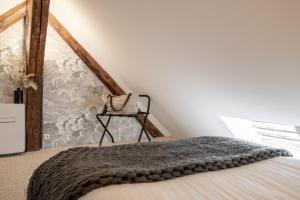 1 dormitorio con 1 cama con manta gris en Studio74 en Annecy