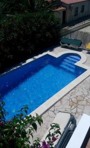 a small blue swimming pool with a bench in a yard at Cassa Jessi in Tarragona