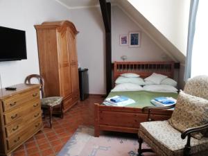 a bedroom with a bed and a chair and a dresser at Siedlisko Sabinowo in Węgorzewo