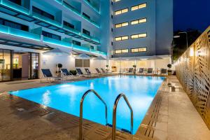 a large swimming pool in a large building at Acandia Hotel in Rhodes Town
