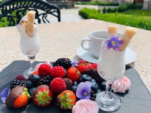 two glasses of ice cream and fruit on a table at Hotel Pałac Poledno in Poledno