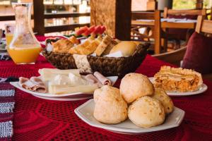 a table with plates of food and a bowl of bread at Pousada Avenida in Monte Verde