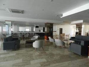 un soggiorno con divani, sedie e tavoli di Evabelle Napa Hotel Apartments a Ayia Napa