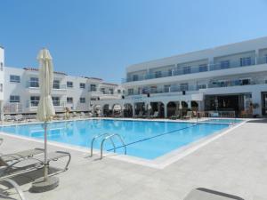 
a swimming pool with a tennis court in the middle of it at Evabelle Napa Hotel Apartments in Ayia Napa
