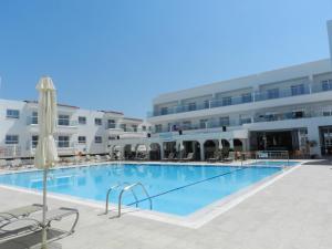 a swimming pool with a large swimming pool in front of a building at Evabelle Napa Hotel Apartments in Ayia Napa