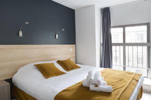 Un dormitorio con una cama con dos animales de peluche encima. en Lille City Hotel, en Lille