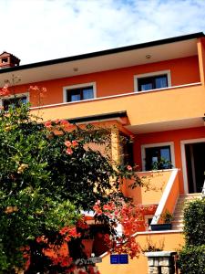 une maison orange avec un arbre en face dans l'établissement Villa Lamanova, à Rovinj