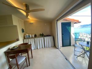a living room with a table and chairs and a balcony at Cà de Marge in Corniglia