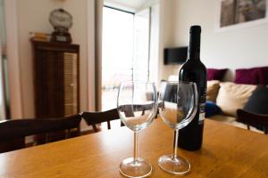 a bottle of wine and two wine glasses on a table at Amazing river view in historical Lisbon in Lisbon