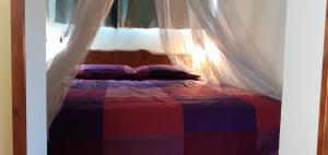1 dormitorio con 1 cama colorida con dosel en Agriturismo Fattoria Corte Roeli, en Malalbergo