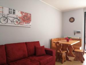 a living room with a red couch and a table at La maison de Lidia in Angera