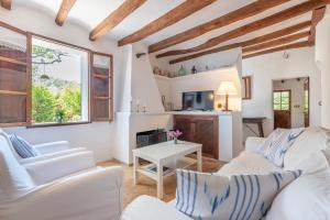 una sala de estar con sofás blancos y una mesa. en Villa Cami de la Mar en Puerto de Sóller